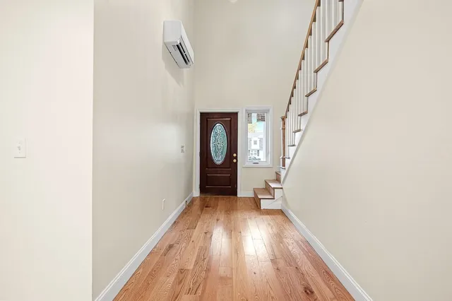 a view of a hallway with wooden floor and entryway