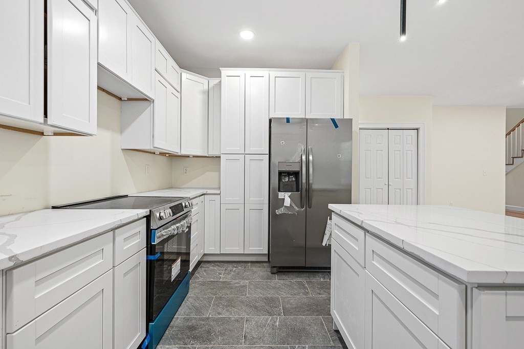 10 Beale Street Worcester, MA 01606 - Photo 9 of 42 a kitchen with a stove a sink and a refrigerator
