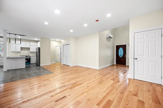 a view of empty room with kitchen and window