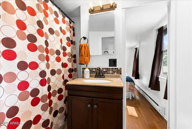 a bathroom with a sink a toilet a mirror and shower curtain