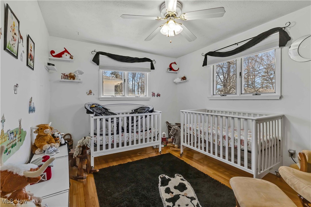 7760 York Road Cleveland, OH 44130 - Photo 14 of 39 Bedroom featuring ceiling fan, a crib, and wood finished floors