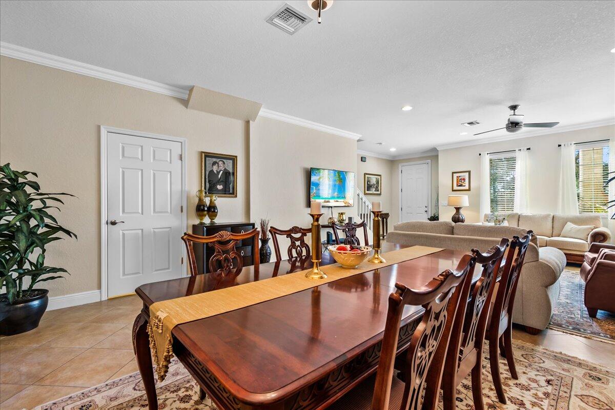 603 Dakota Drive Jupiter, FL 33458 - Photo 9 of 34 a view of a dining room and livingroom with furniture a rug a potted plant and a painting
