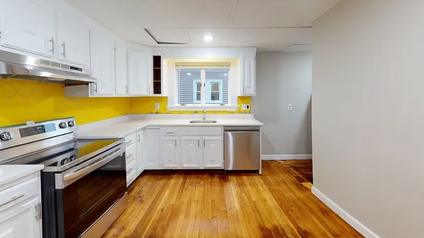 a kitchen with a sink and wooden floor