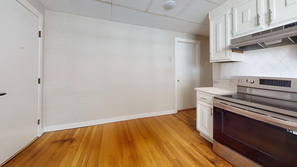 5 Edgar Terrace, Unit 1 Somerville, MA 02145 - Photo 2 of 10 a view of a kitchen with wooden floor and a stove