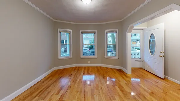a view of wooden floor in an empty room with a window
