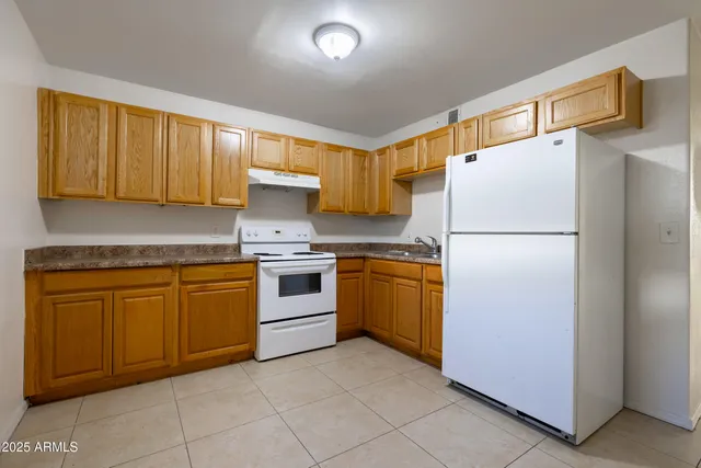 a kitchen with granite countertop cabinets and white appliances