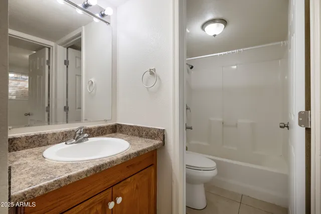 a bathroom with a granite countertop sink toilet a shower and a mirror