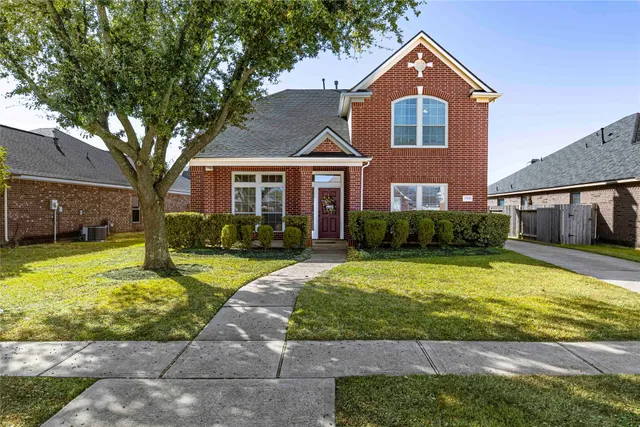 a front view of a house with yard and green space