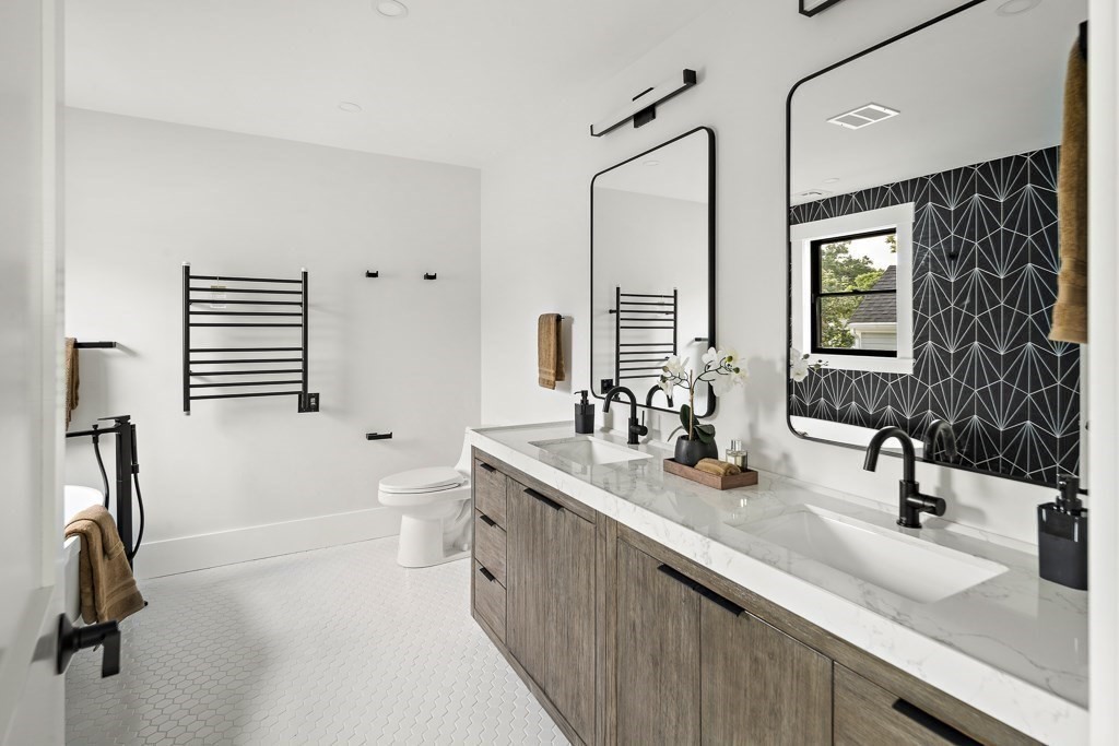 27 Coolidge Avenue Needham, MA 02492 - Photo 21 of 39 a bathroom with a double vanity sink a mirror and a bathtub