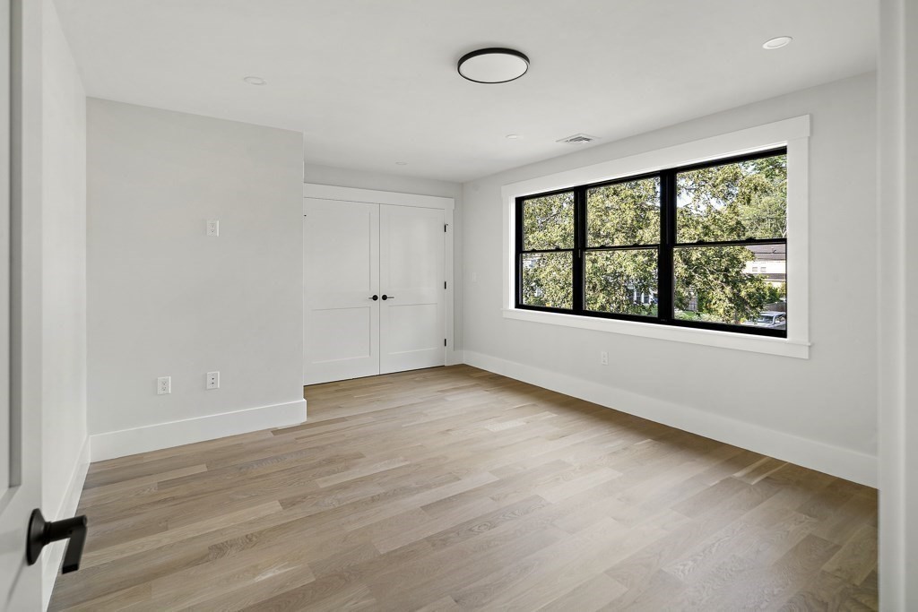 27 Coolidge Avenue Needham, MA 02492 - Photo 23 of 39 an empty room with wooden floor and windows