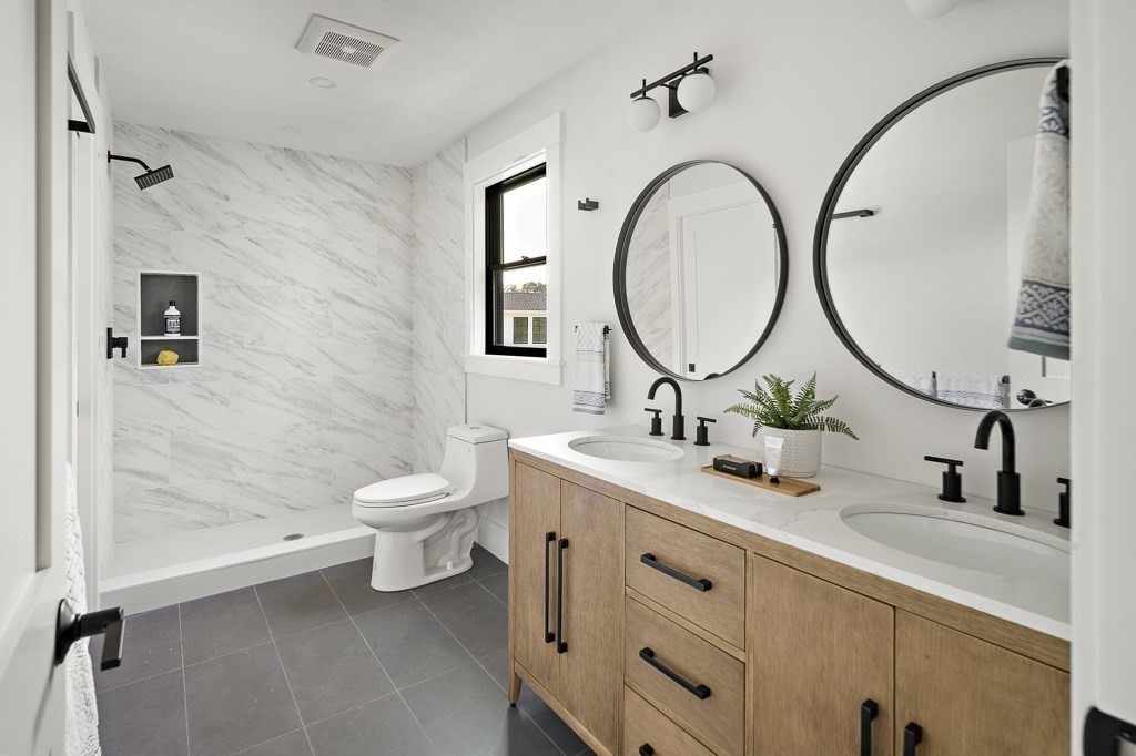 27 Coolidge Avenue Needham, MA 02492 - Photo 25 of 39 a bathroom with a toilet a sink a mirror and a shower