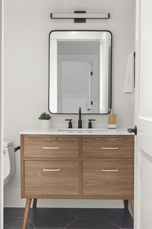 27 Coolidge Avenue Needham, MA 02492 - Photo 30 of 39 a bathroom with a mirror sink and vanity
