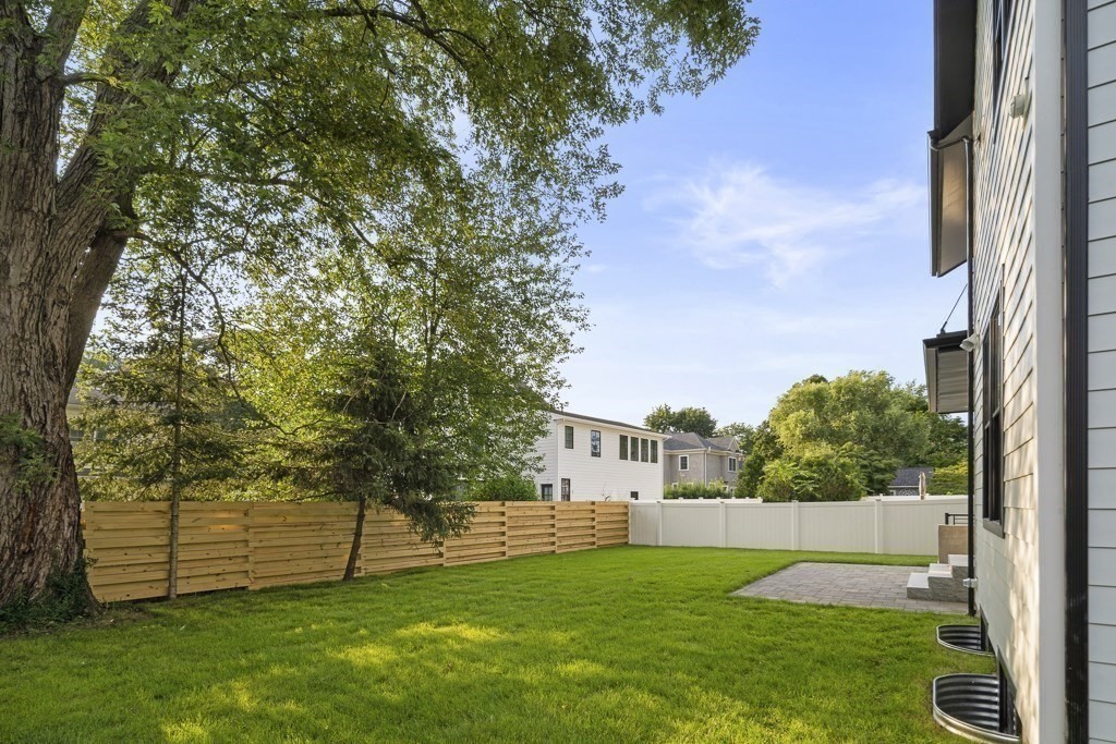 27 Coolidge Avenue Needham, MA 02492 - Photo 38 of 39 a view of a yard with plants and a brick wall
