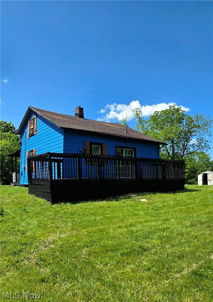 5860 Kirk Road Canfield, OH 44406 - Photo 4 of 12 Blue siding exterior with a dark shingle roof and a brick chimney