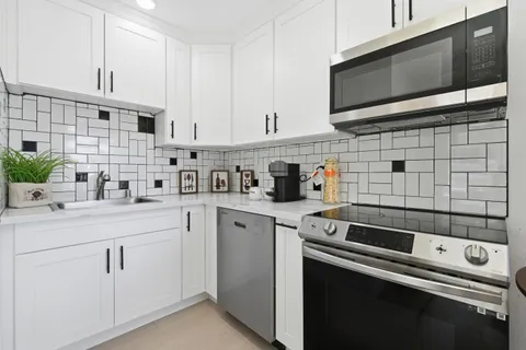 a kitchen with stainless steel appliances white cabinets and a sink