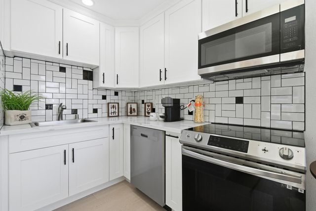 a kitchen with stainless steel appliances white cabinets and a sink