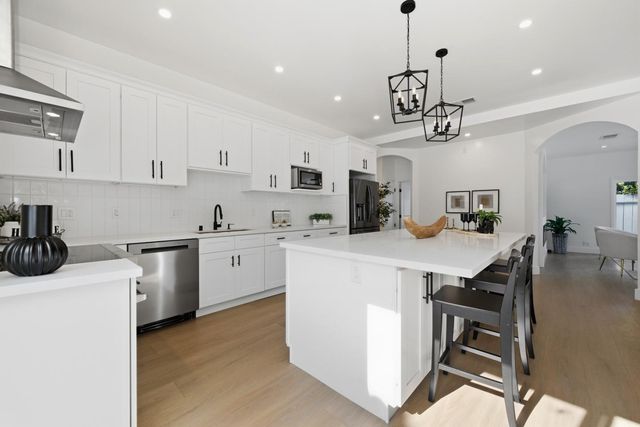 a kitchen that has a lot of cabinets in it and appliances