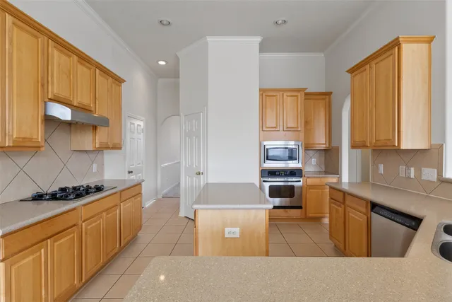 a kitchen with stainless steel appliances granite countertop a stove a sink and a microwave