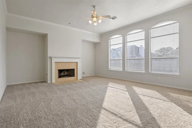 a view of an empty room with a fireplace and a window