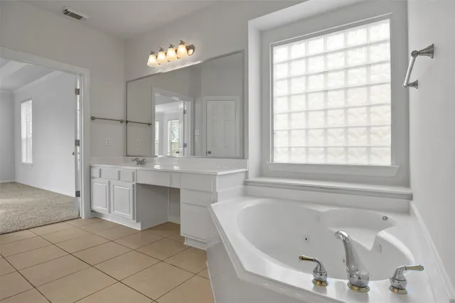 a bathroom with a tub sink and mirror