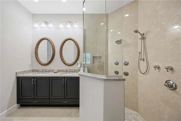 a bathroom with a granite countertop sink a mirror and a shower
