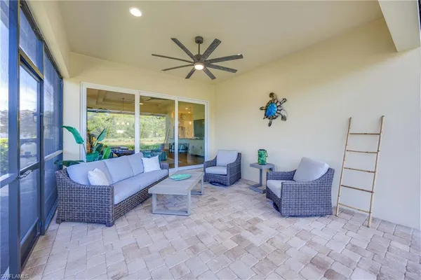 a living room with patio furniture and a potted plant
