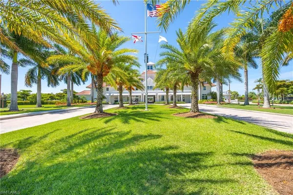 a view of a swimming pool with a lawn chairs under palm trees