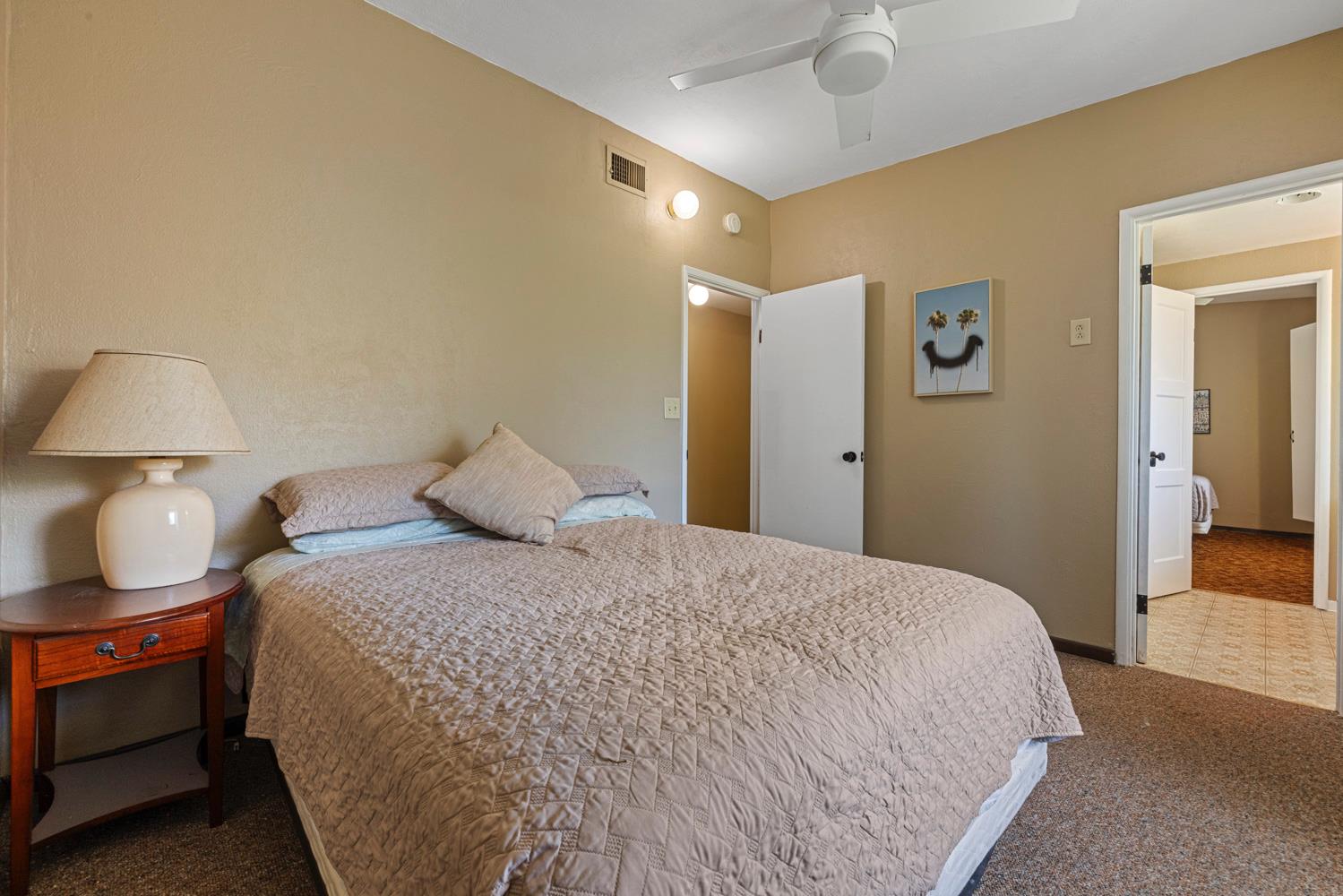 3824 Hubbard Road Stockton, CA 95215 - Photo 16 of 79 a bedroom with a bed and a lamp on dresser