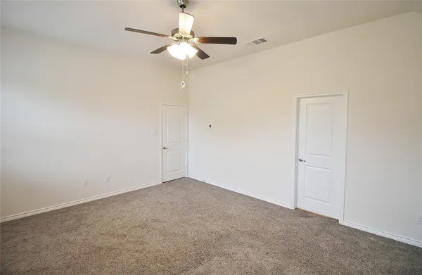 a view of an empty room with a chandelier fan