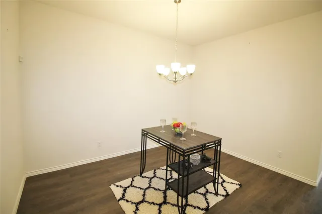 a view of a room with table and wooden floor