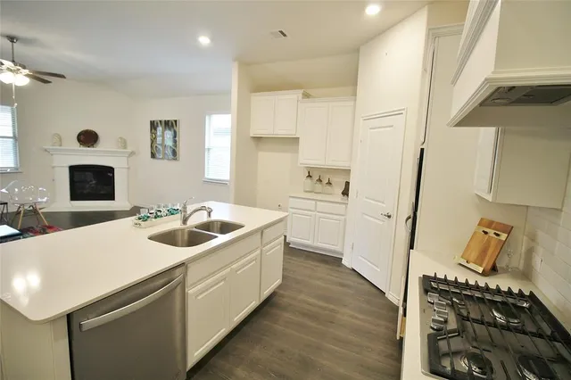 a kitchen with a sink and a stove top oven with wooden floor