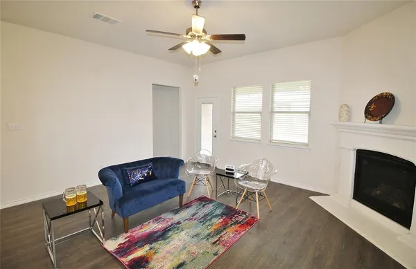 a living room with furniture a fireplace and a chandelier