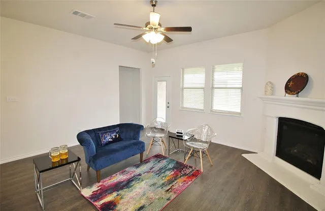 a living room with furniture a fireplace and a chandelier