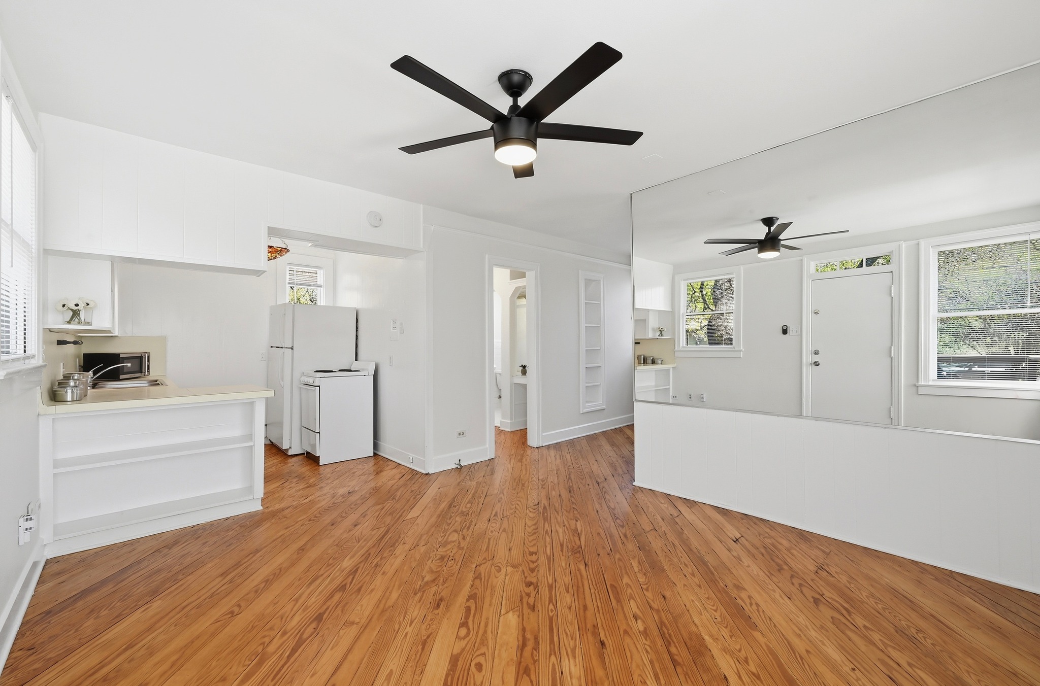 1403 Windsor Road, Unit A Austin, TX 78703 - Photo 1 of 18 a view of empty room with wooden floor and ceiling fan