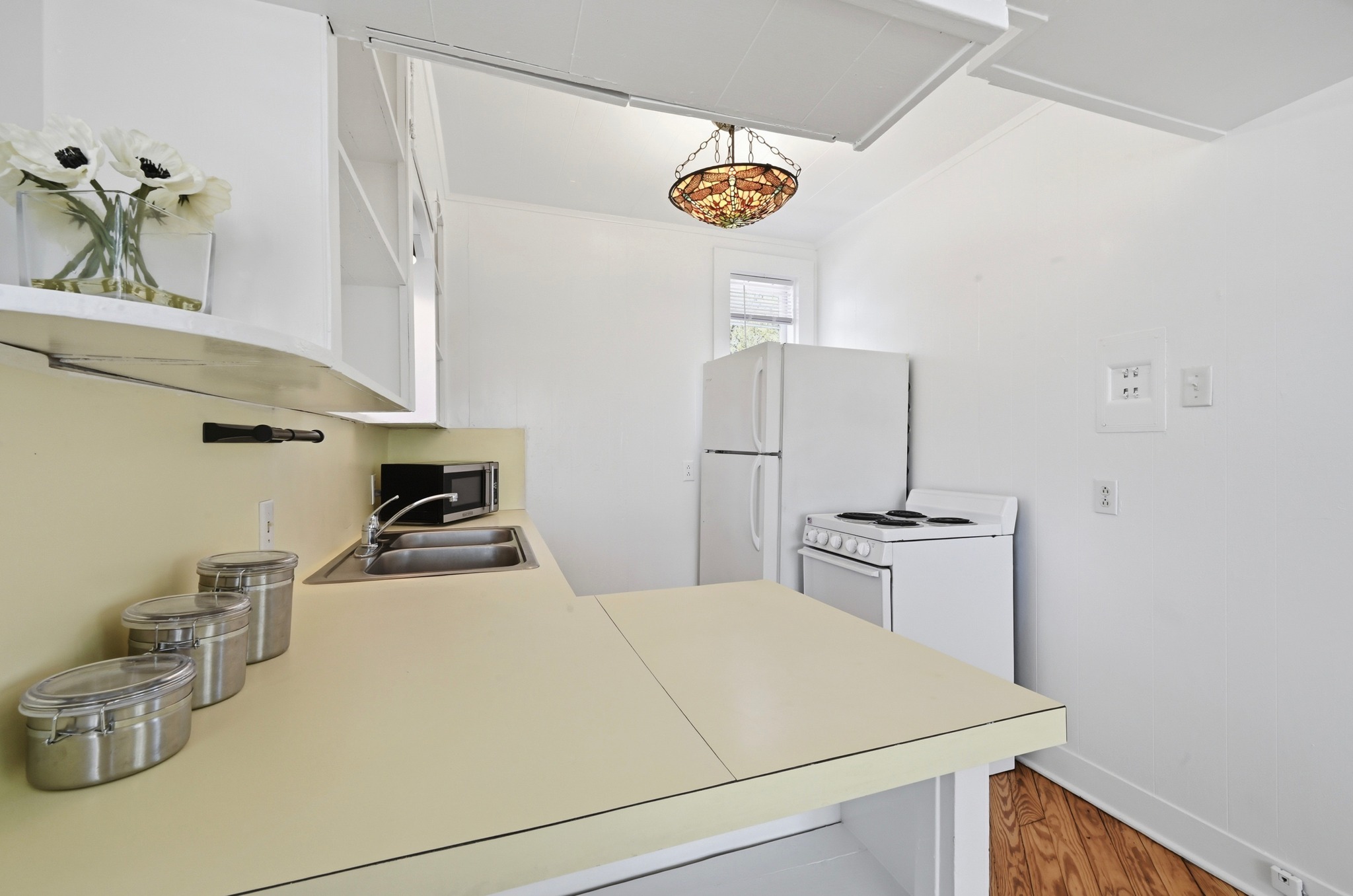1403 Windsor Road, Unit A Austin, TX 78703 - Photo 6 of 18 a room with a refrigerator a sink and cabinets