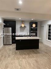 a large kitchen with stainless steel appliances a large counter top