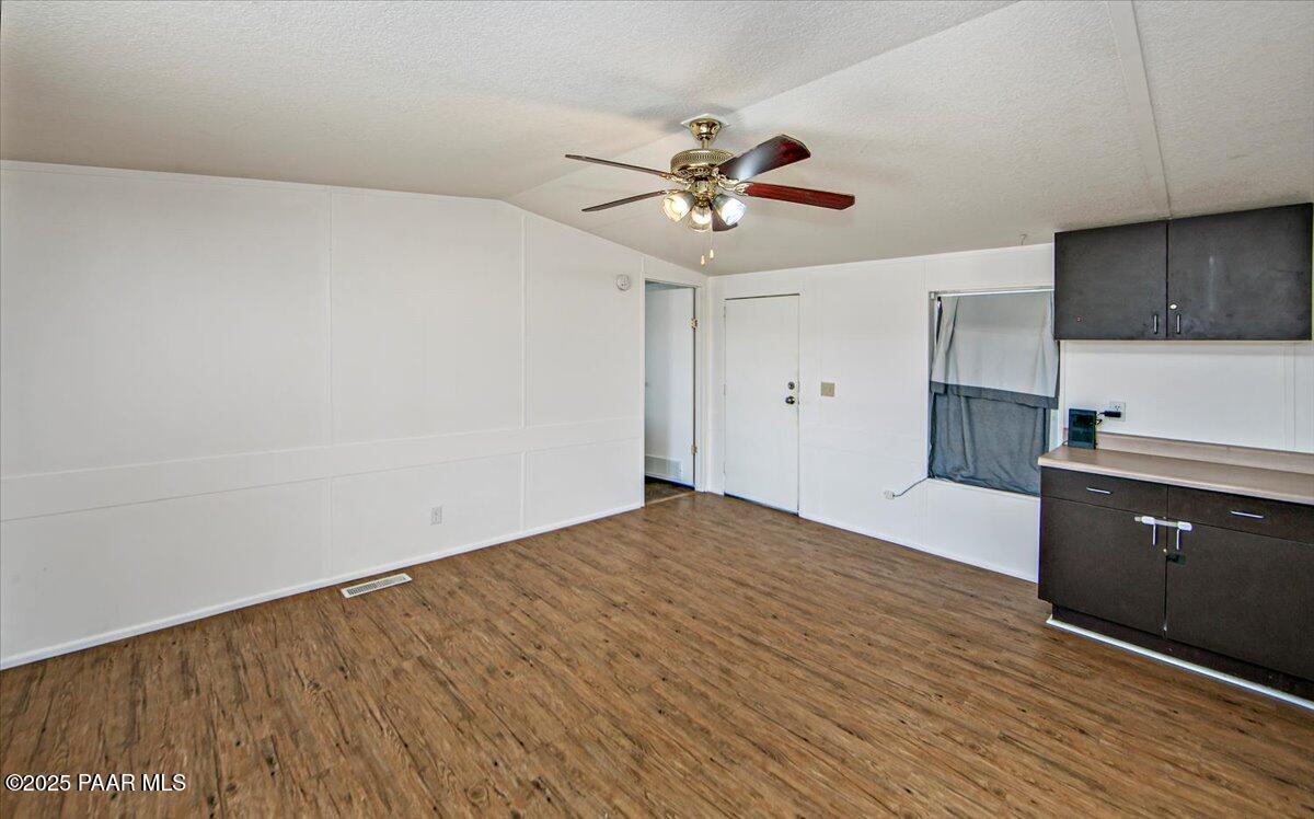 15339 South Rolling Ridge Drive Mayer, AZ 86333 - Photo 6 of 20 a kitchen with a wooden floor and a ceiling fan