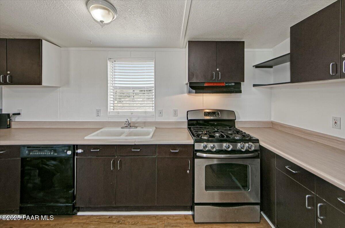 15339 South Rolling Ridge Drive Mayer, AZ 86333 - Photo 9 of 20 a kitchen with granite countertop stainless steel appliances a sink cabinets and a window