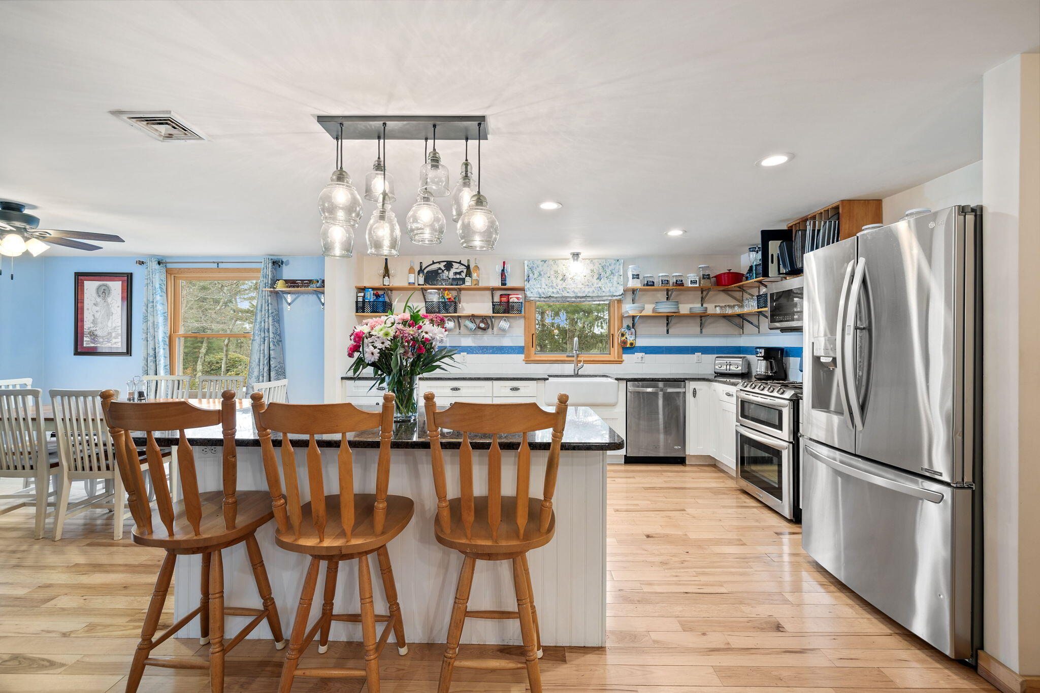 11 Michael Road Pocasset, MA 02559 - Photo 12 of 35 a kitchen with stainless steel appliances kitchen island granite countertop a dining table chairs and a refrigerator