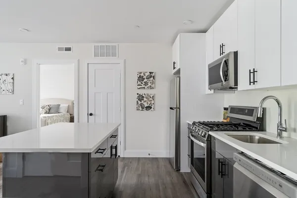 a kitchen with granite countertop a sink stove and cabinets