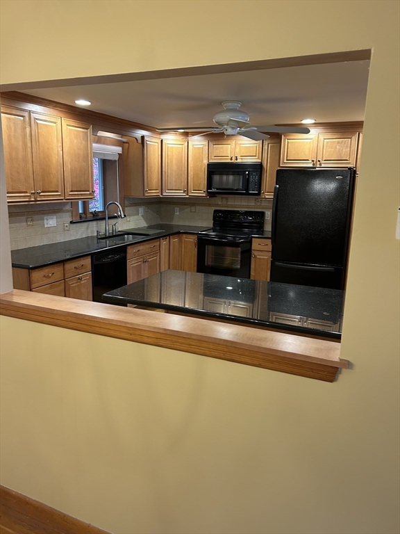 21 Athens Drive Saugus, MA 01906 - Photo 9 of 18 a kitchen with stainless steel appliances granite countertop a refrigerator a stove and a sink with wooden floor