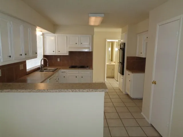 a view of a kitchen with white cabinets