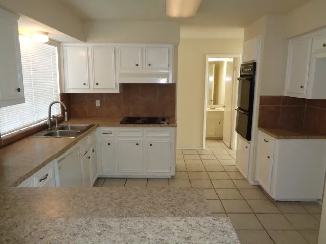 a kitchen with a sink stove and cabinets