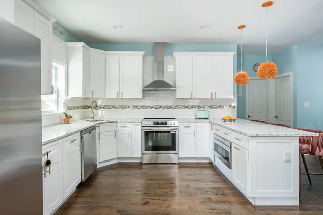 a living room with stainless steel appliances kitchen island granite countertop furniture and a rug