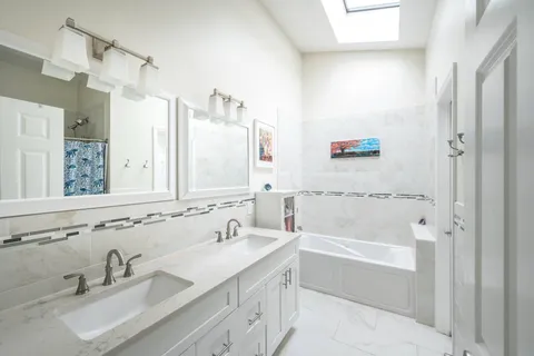 a bathroom with a tub sink and mirror