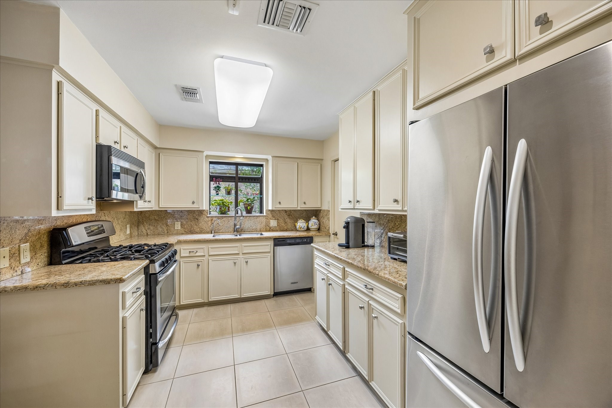 307 Oarman Court Houston, TX 77079 - Photo 14 of 38 a kitchen with stainless steel appliances granite countertop a refrigerator a sink dishwasher a stove with white cabinets and wooden floor