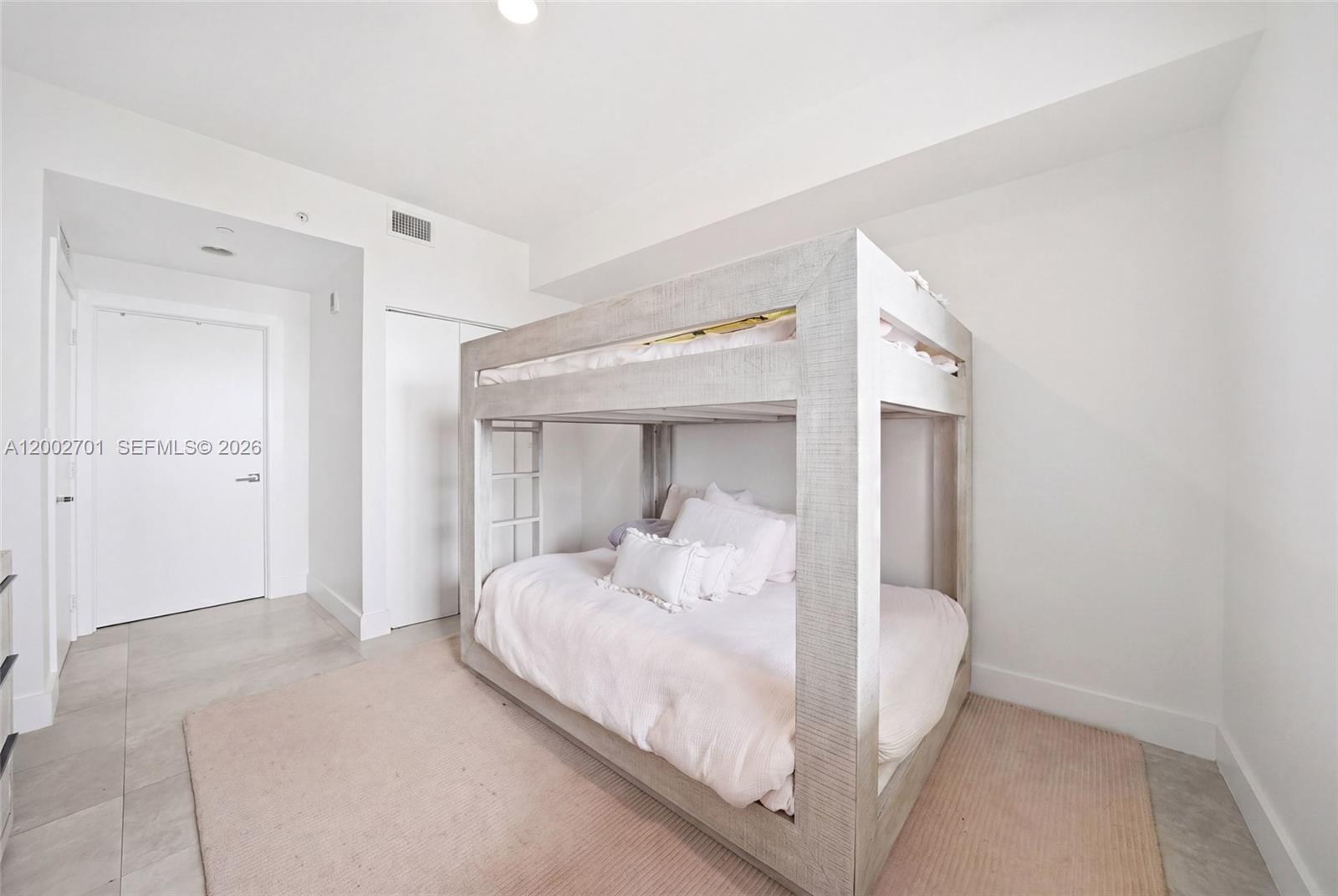 600 Northeast 27th Street, Unit 1002 Miami, FL 33137 - Photo 14 of 30 a bedroom with a bed and a mirror