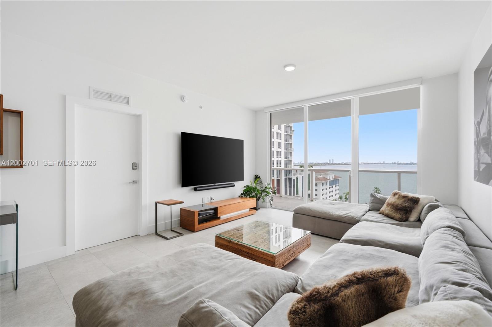 600 Northeast 27th Street, Unit 1002 Miami, FL 33137 - Photo 3 of 30 a living room with furniture and a flat screen tv