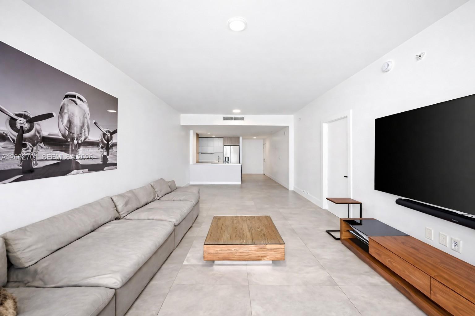 600 Northeast 27th Street, Unit 1002 Miami, FL 33137 - Photo 4 of 30 a living room with furniture and a flat screen tv