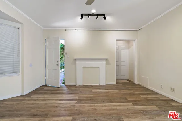 a view of a livingroom with wooden floor and a hallway
